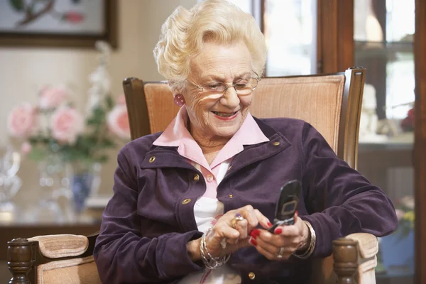 Starszy kobieta wiadomości tekstowych — Zdjęcie stockowe