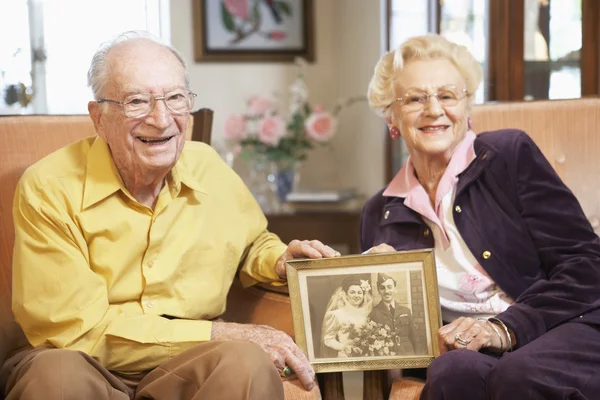 Starszy para trzyma zdjęcie ślubne — Zdjęcie stockowe