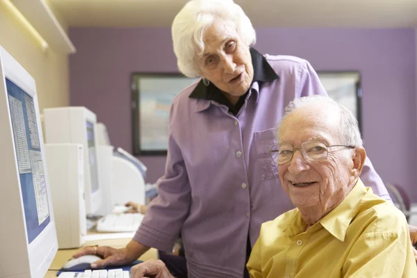Starszy kobieta pomaga starszy człowiek wykorzystania komputera — Zdjęcie stockowe
