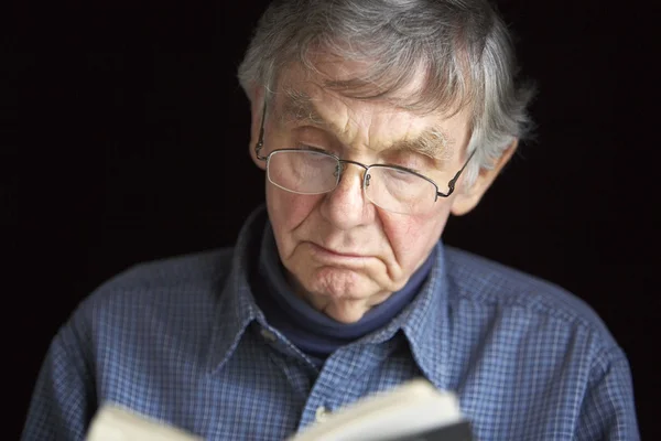 Senior man läser en bok — Stockfoto