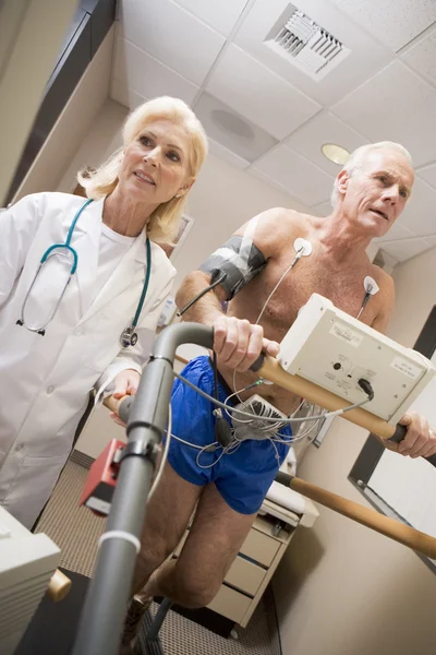 Arzt überwacht die Herzfrequenz des Patienten auf einem Laufband — Stockfoto
