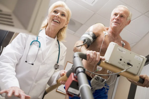 Médecin surveillant la fréquence cardiaque du patient sur un tapis roulant — Photo