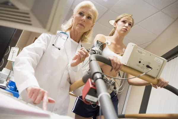 Médico monitoreando la frecuencia cardíaca del paciente en una cinta de correr — Foto de Stock