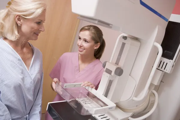 Enfermeira auxiliar paciente prestes a fazer uma mamografia — Fotografia de Stock