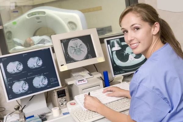 Verpleegkundige toezicht patiënt met een geautomatiseerde axiale tomografie — Stockfoto