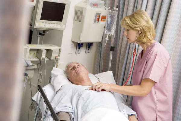 Доктор проверяет сердцебиение пациента — стоковое фото