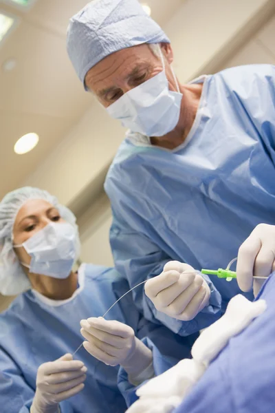 Cirurgiões preparando equipamentos para cirurgia — Fotografia de Stock