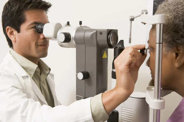 Доктор проверяет глаза пациентки. — стоковое фото