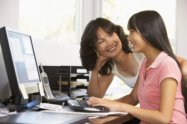 女人看着她的女儿使用一台计算机 — 图库照片