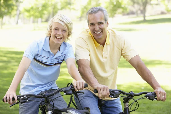 父亲和儿子骑自行车穿过公园 — 图库照片