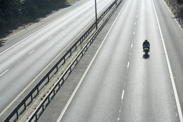 Boş bir karayolu üzerinde Lone motorcu — Stok fotoğraf