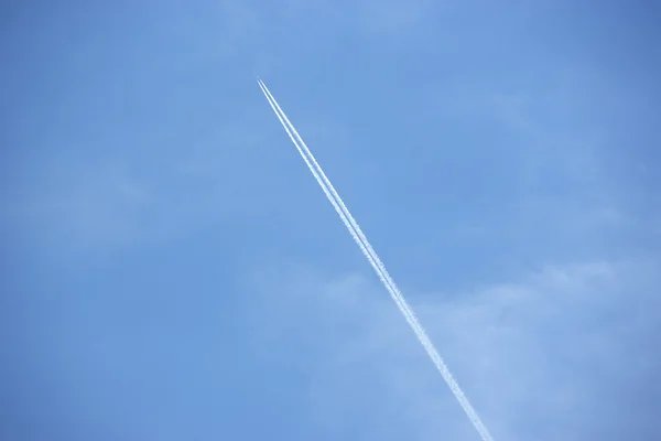 青い sk を越えて飛ぶジェット機から飛行機雲をホワイトします。 — ストック写真