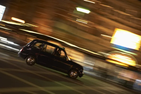Táxi dirigindo através do tempo noite rua — Fotografia de Stock