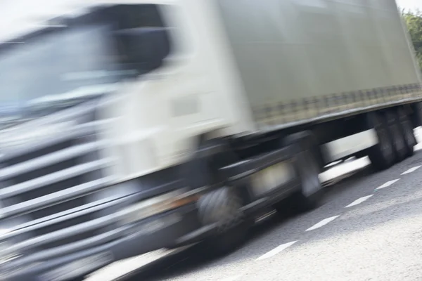 Vrachtwagen rijden langs de weg — Stockfoto