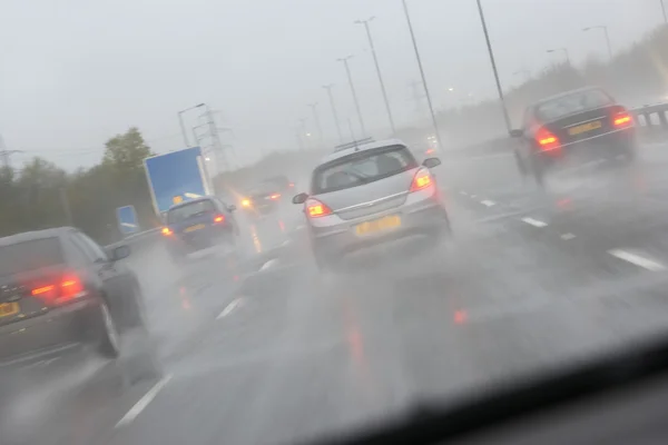 汽车驾驶在一场雨弄得油光光公路 — 图库照片