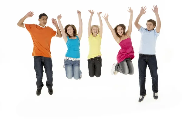 Groep van vijf jonge kinderen springen in studio — Stockfoto
