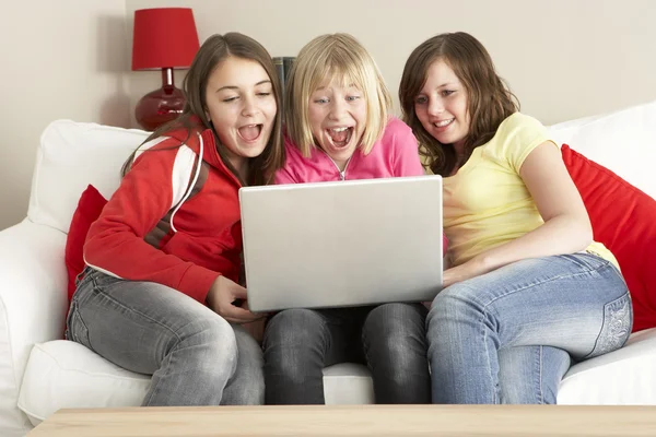 Grupo de três meninas usando laptop em casa — Fotografia de Stock