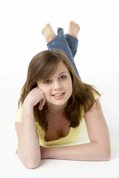 Jong meisje liggend op de buik in studio — Stockfoto