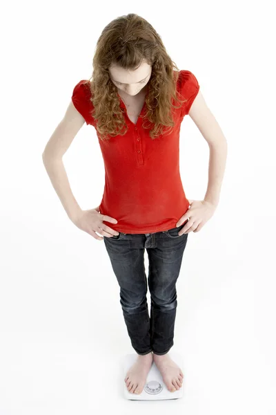 Нещаслива молода дівчина стоїть на вагах — стокове фото