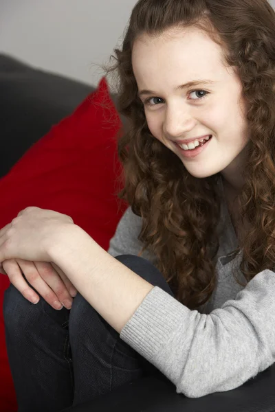 Tonårig flicka sitter på soffan — Stockfoto