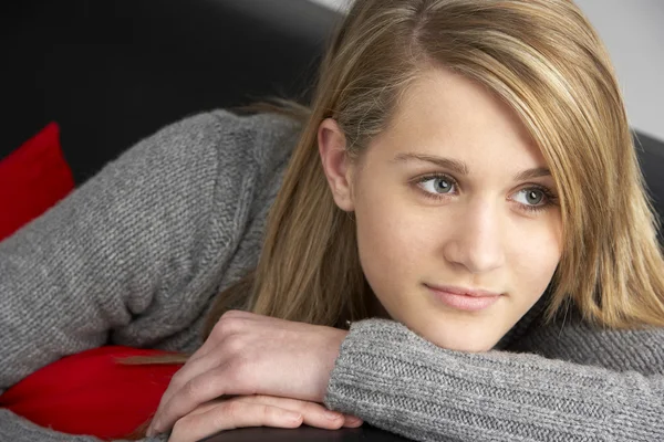 Dospívající dívka sedí na pohovce — Stock fotografie