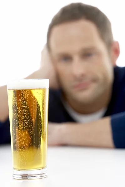 Hombre mirando un vaso de cerveza — Foto de Stock