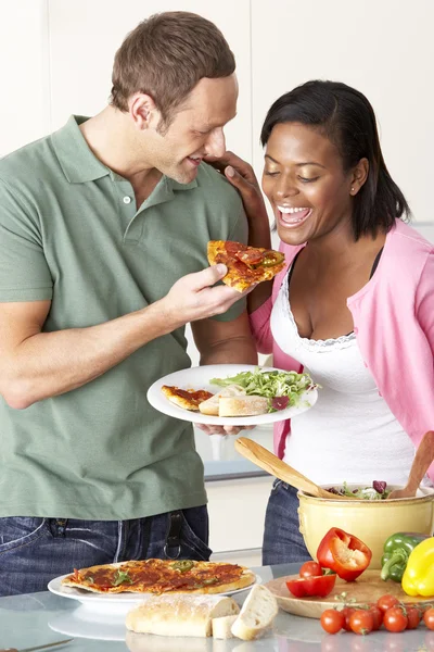 Молодая пара ест еду на кухне — стоковое фото