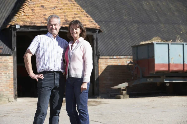 Agricultor y esposa de pie frente a los edificios de la granja —  Fotos de Stock
