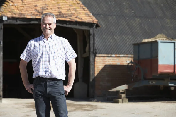 Farmer Standing In Front Of Farm Buildings — Stock Photo, Image
