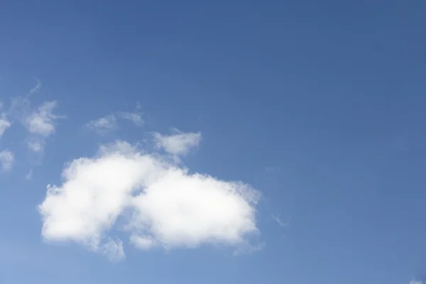 Witte pluizige wolk tegen blauwe hemel — Stockfoto