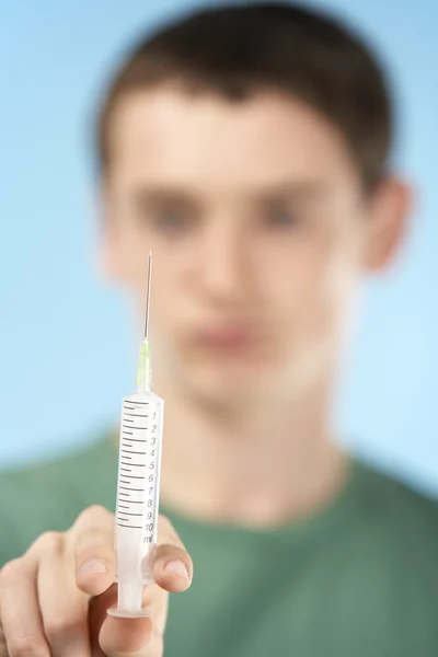 Adolescente menino segurando seringa — Fotografia de Stock