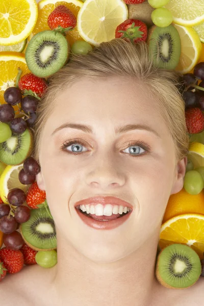 Retrato de mulher jovem cercada por frutas — Fotografia de Stock