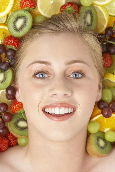 Retrato de mulher jovem cercada por frutas — Fotografia de Stock