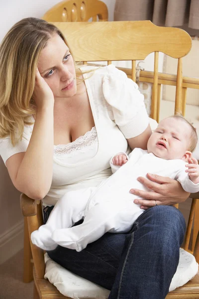 Mãe preocupada segurando bebê no berçário — Fotografia de Stock