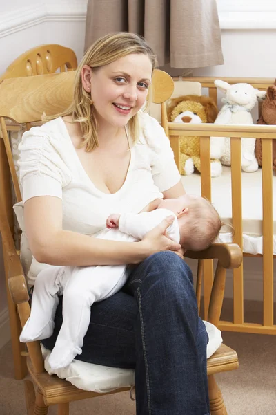 Мать кормит грудью ребенка в яслях — стоковое фото