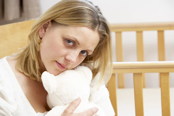 Traurige Mutter sitzt in leerem Kinderzimmer — Stockfoto