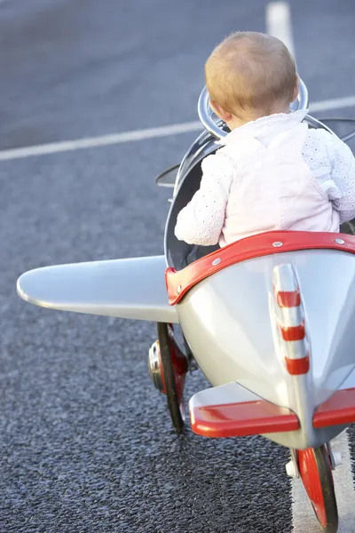 Mädchen reitet in Spielzeugflugzeug — Stockfoto
