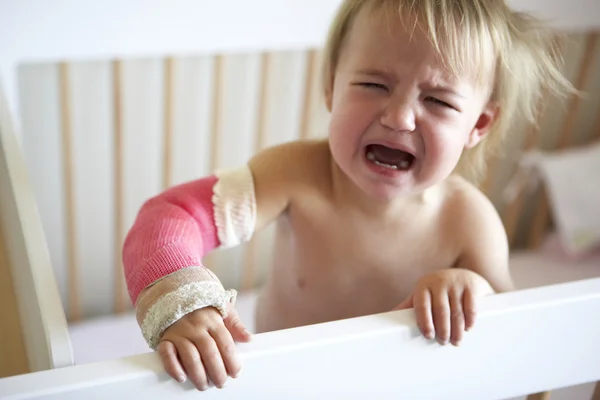 Criança chorando com braço no elenco — Fotografia de Stock