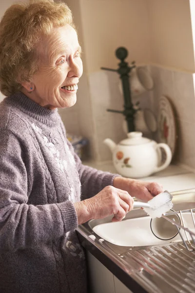 Пожилая женщина умывается у раковины — стоковое фото