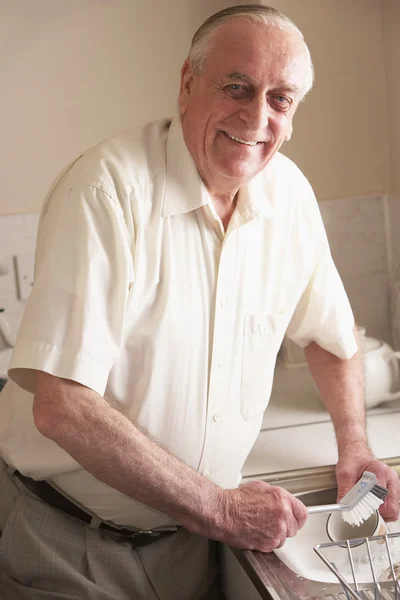 Starší muž, mytí nádobí v dřezu — Stock fotografie