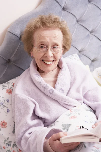 Senior Vrouw Ontspannen Bed Met Boek — Stockfoto