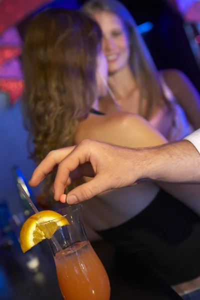 Мужчина накачивает женщину напитком в баре — стоковое фото
