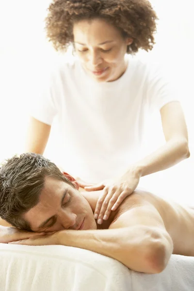 Молодой человек наслаждается массажем в спа — стоковое фото