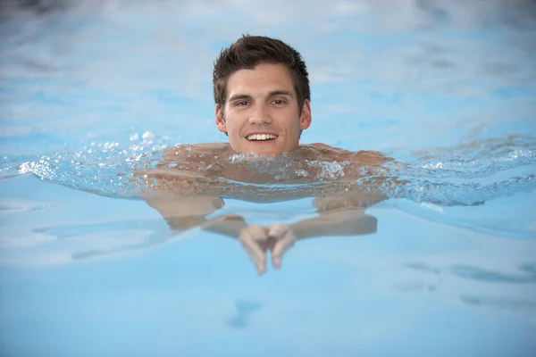 Młody człowiek pływa w basenie — Zdjęcie stockowe