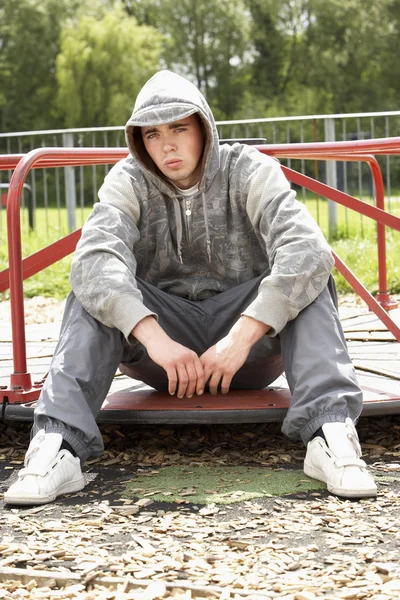 Fiatal férfi ült a játszótér — Stock Fotó