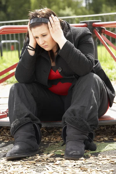 Junge Frau Sitzt Auf Spielplatz — Stockfoto