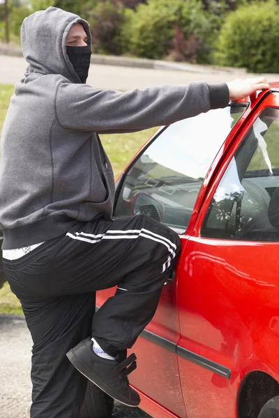 Junger Mann bricht in Auto ein — Stockfoto