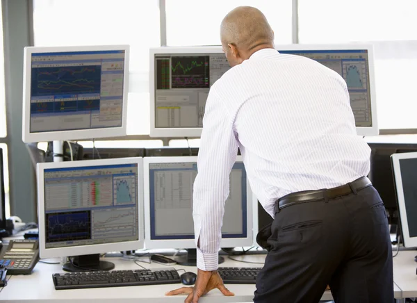 Aktienhändler blickt auf mehrere Monitore — Stockfoto