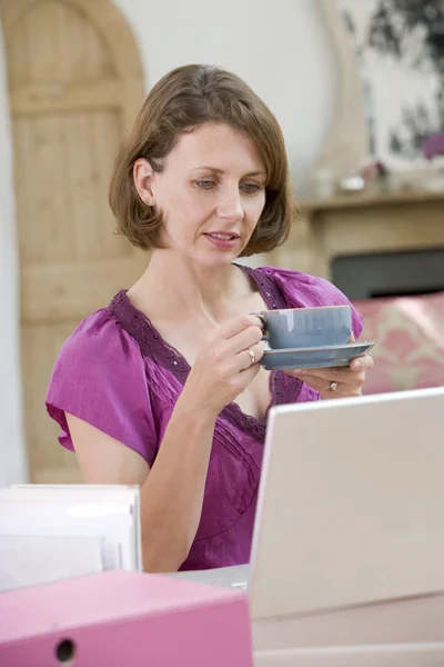 Mulher bebendo café em sua mesa — Fotografia de Stock