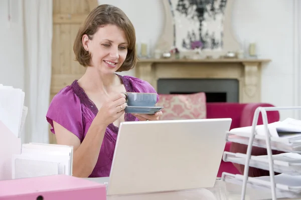 Žena u svého stolu pití kávy — Stock fotografie